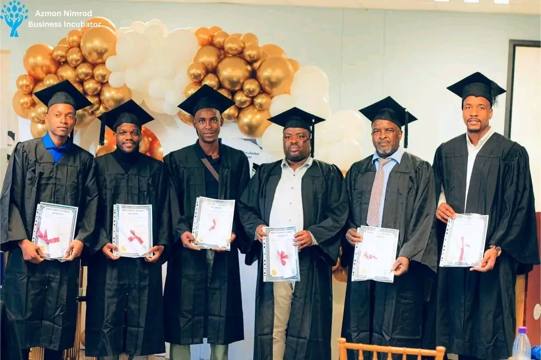 Graduates in caps and gowns celebrating at the ANBI graduation ceremony