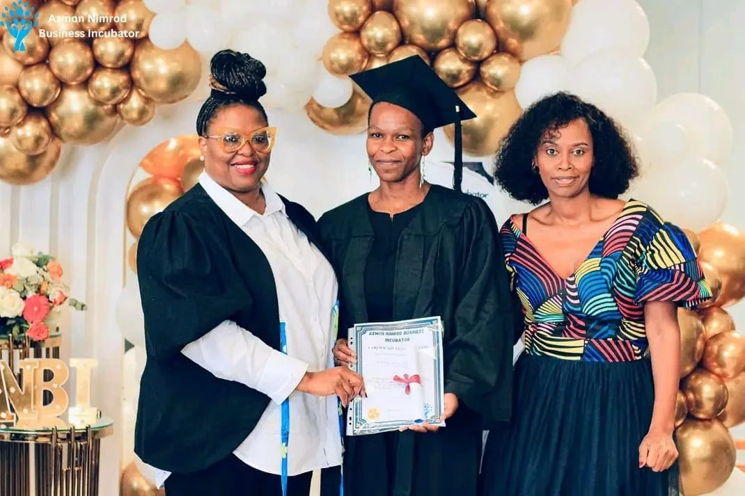 Graduates in caps and gowns celebrating at the ANBI graduation ceremony
