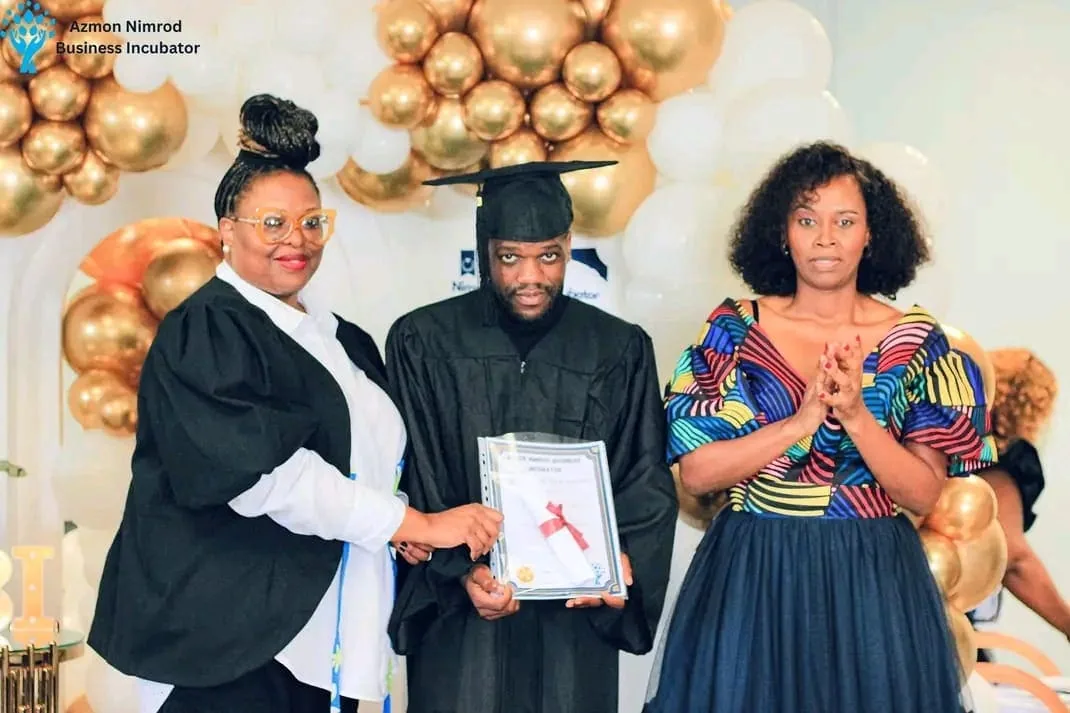 Graduates in caps and gowns celebrating at the ANBI graduation ceremony