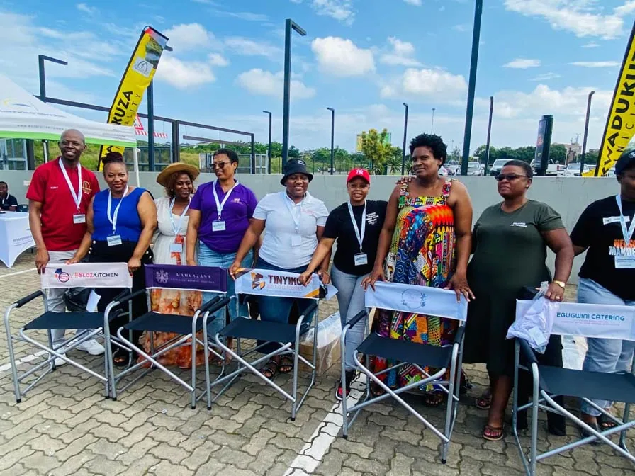 Founders standing behind director's chairs branded with their own business logos at an ANBI event