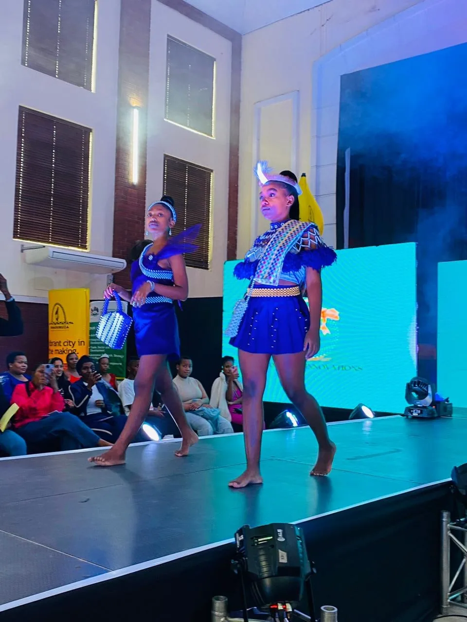 A model in a blue traditional-print outfit walking the runway