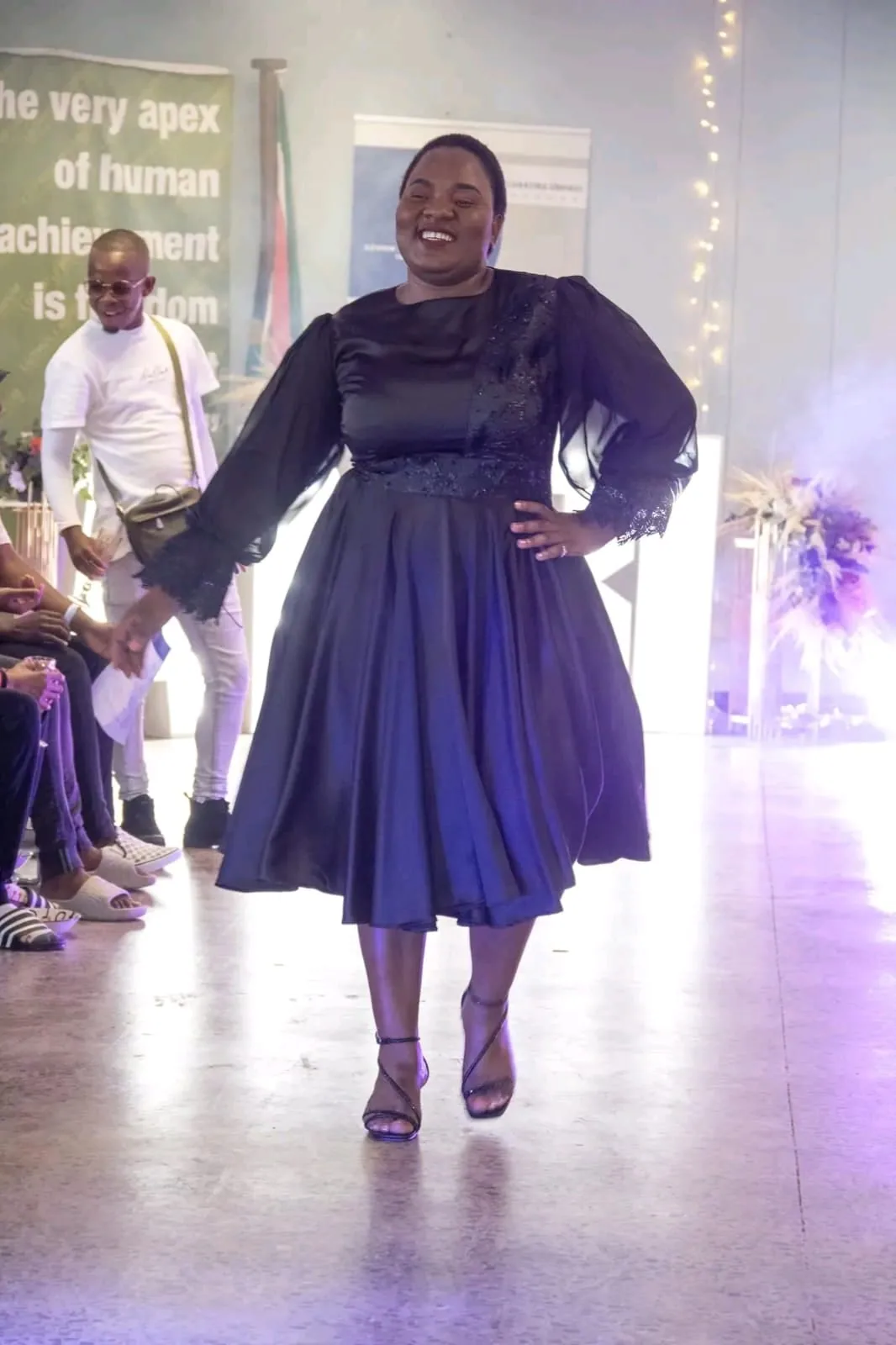 A model in a navy dress on the runway at the ANBI showcase