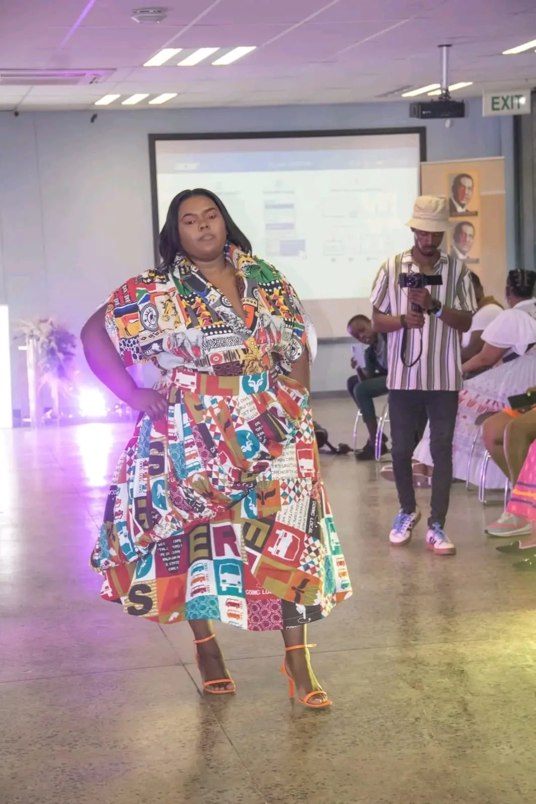 A model in a striking newspaper-print outfit on the runway