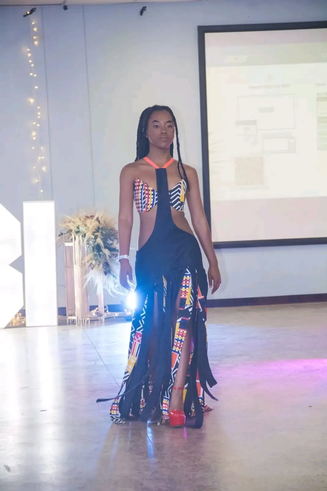 A model in a sheer sequinned gown among the fairy lights